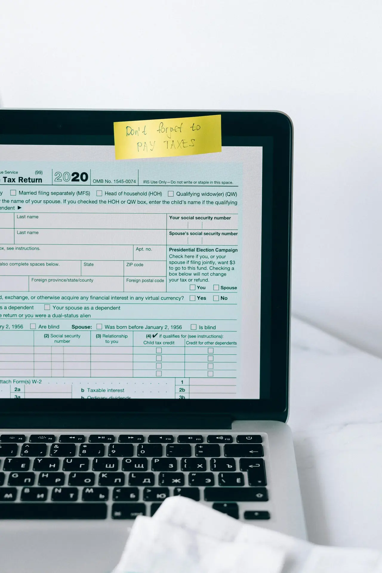 Laptop showing tax form with a reminder note, emphasizing tax payment.